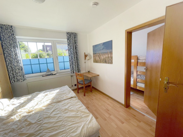 Helles Schlafzimmer mit Doppelbett und Zugang zum weiterem Zimmer in Appartement Boje 27-5.